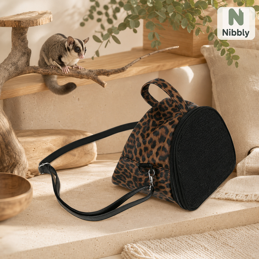Nibbly GliderPod Carrier beside a relaxed sugar glider in a warm habitat setting